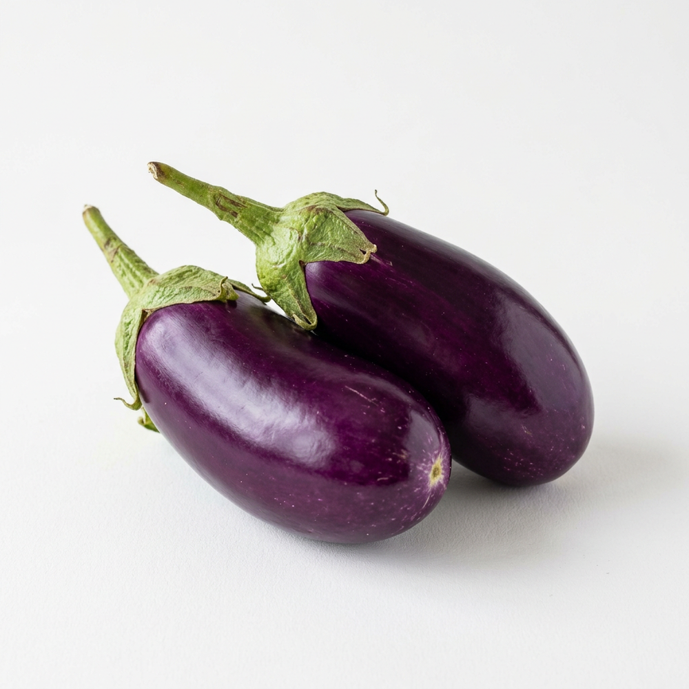 Fresh purple brinjal eggplants on white background