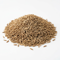 A mound of whole jeera (cumin seeds) on a clean white background